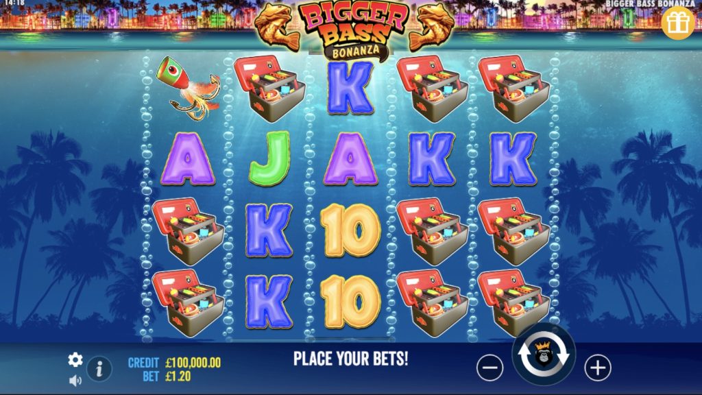 Pantalla de juego de Bigger Bass Bonanza. Los rodillos de la tragaperras muestran símbolos como el Cofre del Tesoro, el Pez y las letras A, J, K y el número 10. El saldo del jugador es de 100.000,00 £ con una apuesta de 1,20 £. De fondo, un paisaje tropical con palmeras y luces de ciudad.